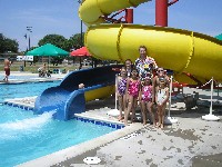 Teacher and students stand by water park slide